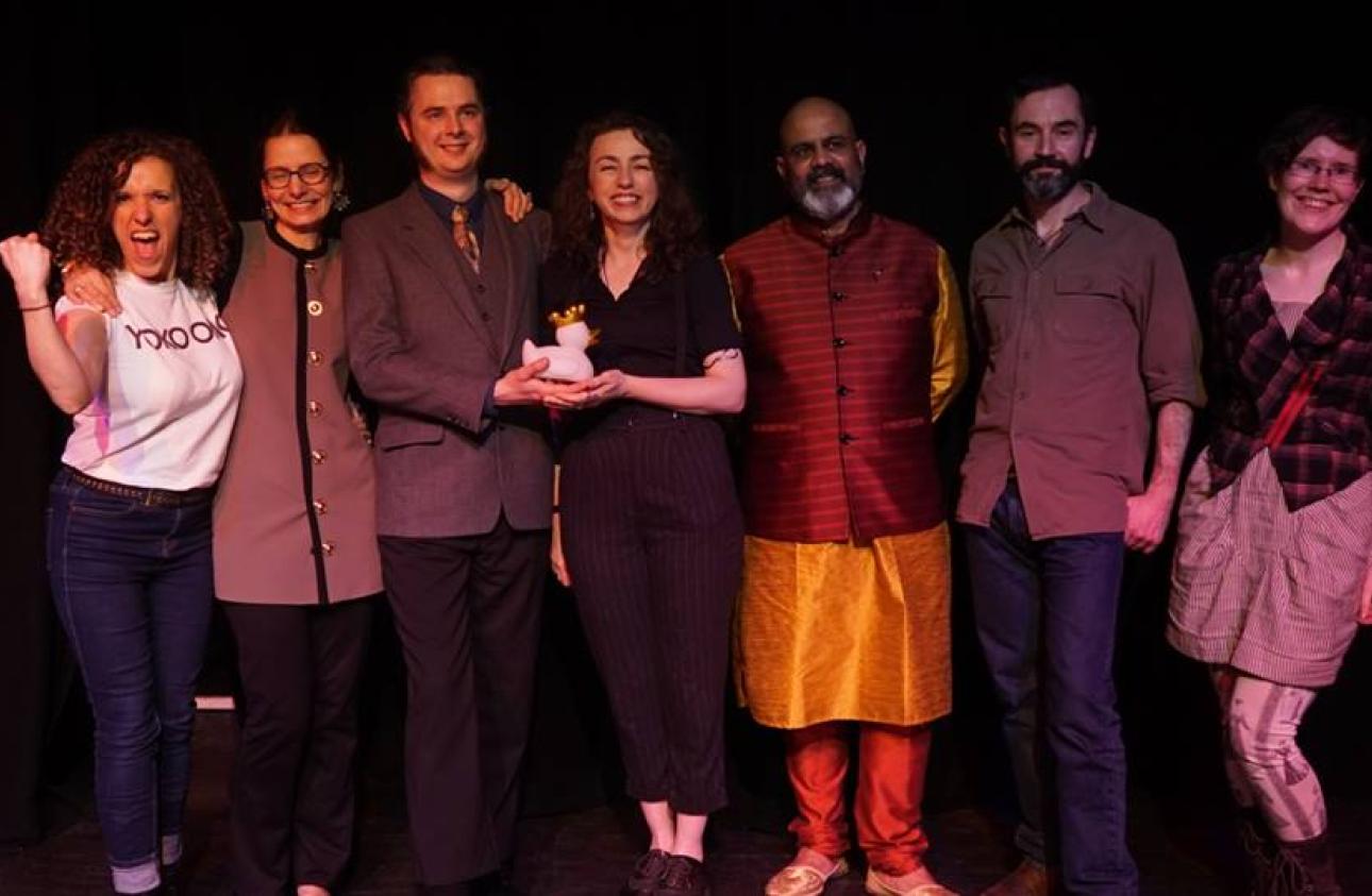 A whole line up of storytellers at the end of a performance, all smiling