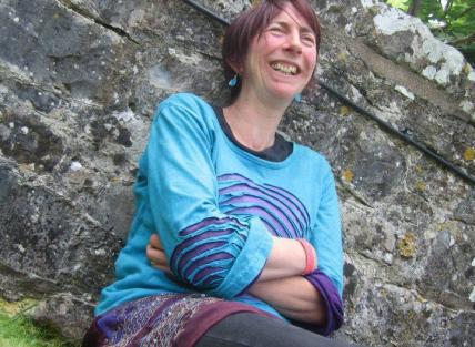 Photo of Rachel sat next to a wall. 