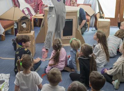 A photograph of Monika talking to young people.