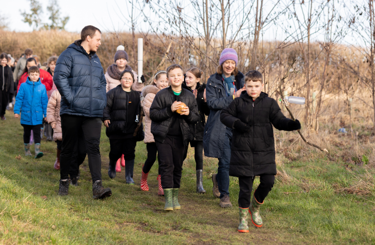 A group of children walking through the woodlands 